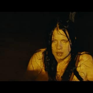 Protagonista do filme Animais Perigosos (2025) em cena de suspense no mar, representando o terror psicológico e a vulnerabilidade da personagem