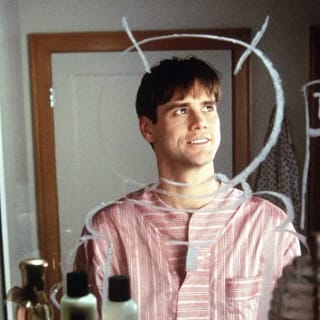 Jim Carrey jovem olhando para espelho com desenhos, simbolizando origem do humor