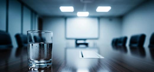 Copo d’água sobre mesa de entrevista de emprego, símbolo de poder e performance corporativa