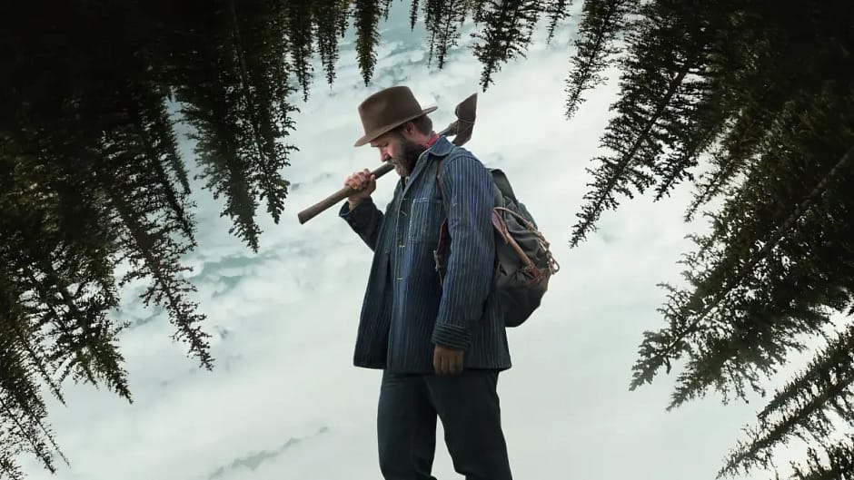 Joel Edgerton como Robert Griner com um machado na neve em cena do filme Sonhos de Trem (2024)